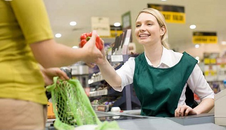 Female cashier and customer at supermarket checkout